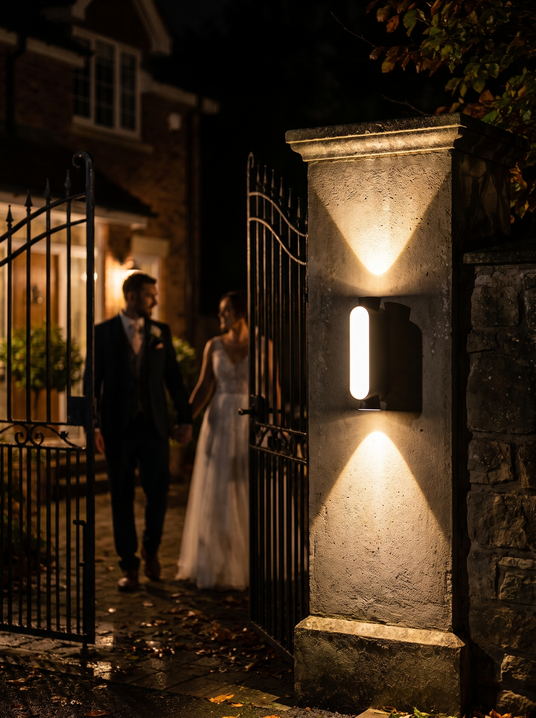 Manon slim up and down sconce on a gatepost at night