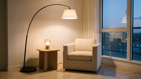 Matte black arc floor lamp and ribbed glass table lamp lit in a living room corner at dusk